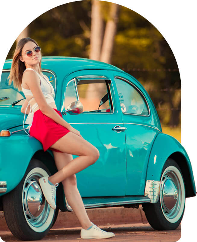 Elegant woman next to a turquoise classic car, promotional image for auto insurance and lifestyle at Univista Insurance
